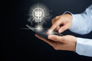 Pessoa utilizando tablet com ícone de lâmpada digital representando inovação e IA